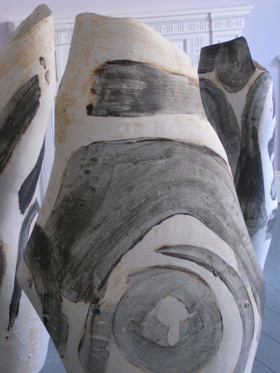 Close view of three vessels with sweeping grey-black brushwork